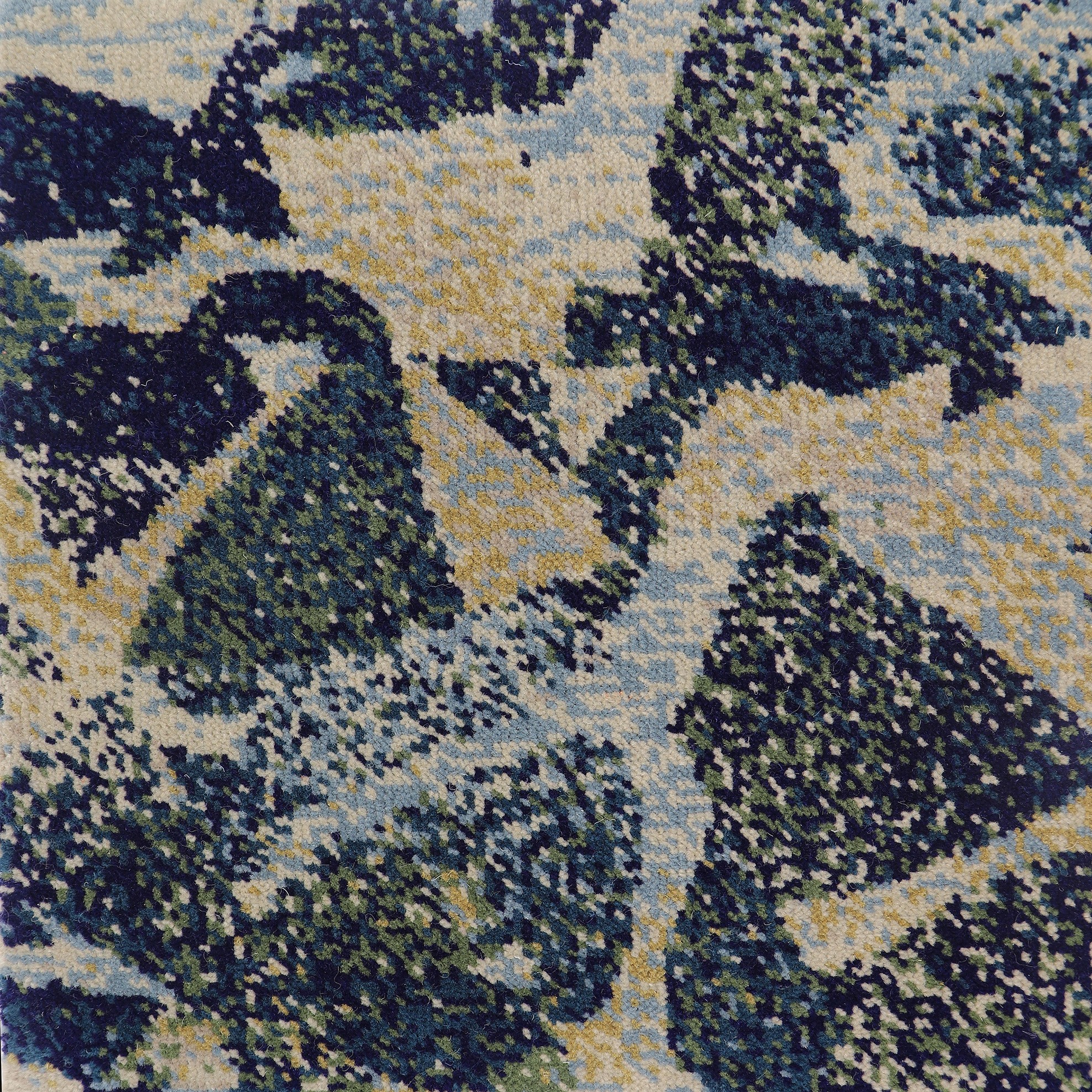 Close-up of woven Axminster carpet pattern tiles showing the dense tufted pile and colour registration